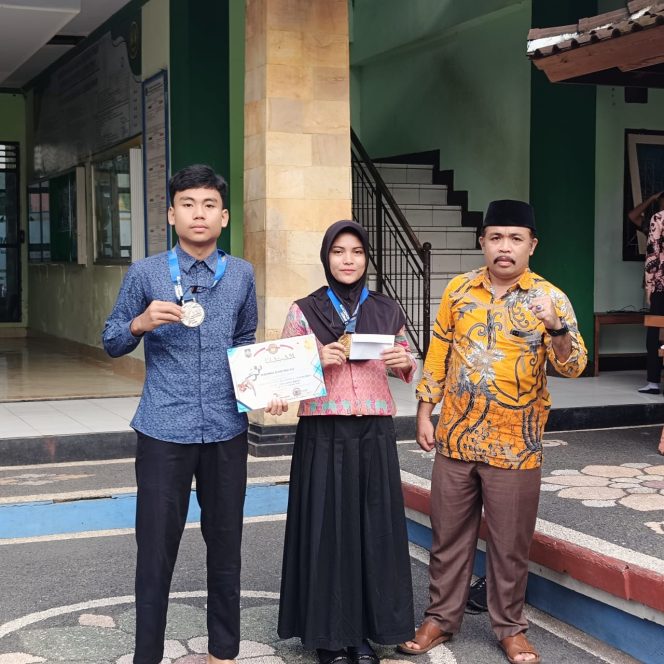 
 Foto : Dua duasiswa MAN 1 Lotim sukses meraih prestasi juara yakni ;  Witriyani Azzahro meraih medali emas (juara 1) prestasi kyorugi putri U-46 dan Muhammad Riandi Maulana meraih medali perak (juara 2) prestasi kyorugi putra U-59 didampingi Kepala Man 1 Lombok Timur M Nurul Wathoni 
