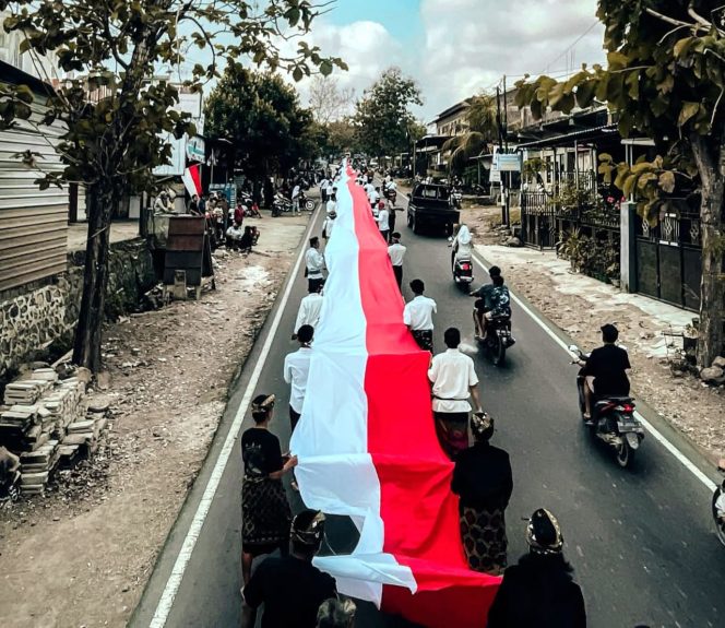 
 Foto : Pemuda Desa Rensing Kecamatan Sakra Barat bentangkan bendera merah putih sepanjang 500 Meter pada acara karnaval HUT RI pada hari senin (25/08). Sumber foto (Pemuda Desa Rensing)