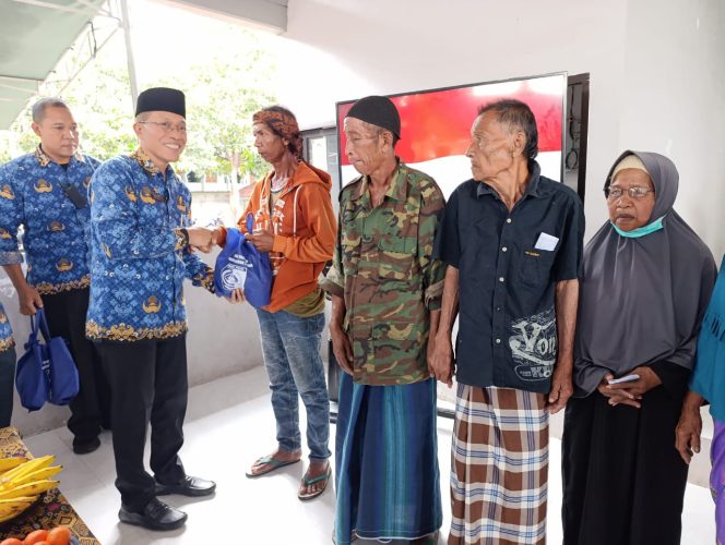 
 Foto : Sekretaris Daerah Lombok Timur HM Juaini Taofik membangikan sembako di wilayah Pringgebaya Rabu ( 17/12).